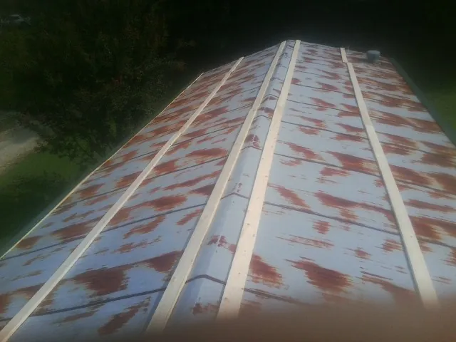 Rusted metal roof panels with new wood purlins before replacement — Storm Damage Roof Repair in Hopkins by Roofing Brothers
